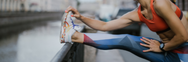 a-woman-wearing-leggings-and-sports-bra-while-stretching-her-legs