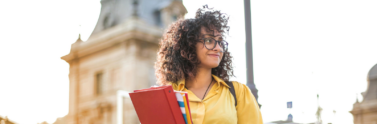 person-in-yellow-jacket-holding-books