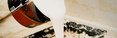 person-pouring-white-paint-on-container