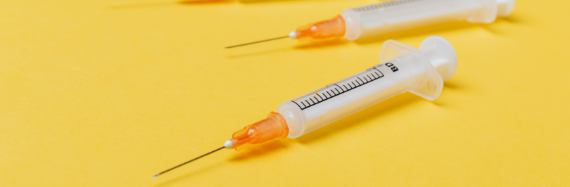 syringe-injectors-placed-on-yellow-surface
