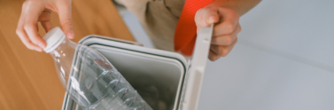 person-disposing-plastic-bottles-into-container