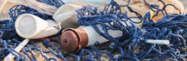 Discarded plastic bottles, net, and plastic on beach