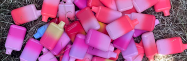 Colourful vapes in a pile on the ground