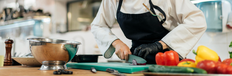 Culinary student chopping vegetables in kitchen