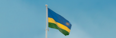 Rwandan flag on flagpole with blue skies
