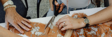 Two people cutting up old fabric