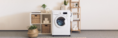 White washing machine surrounded by cleaning products on shelves