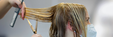 Person wearing a mask getting their hair cut